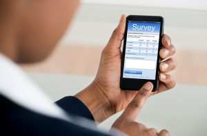 Close-up Of A Businesswoman Filling Online Survey Form On Mobile Phone
