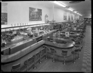 Two views of a long soda fountain at a S.S. Kresge store, 1954. 