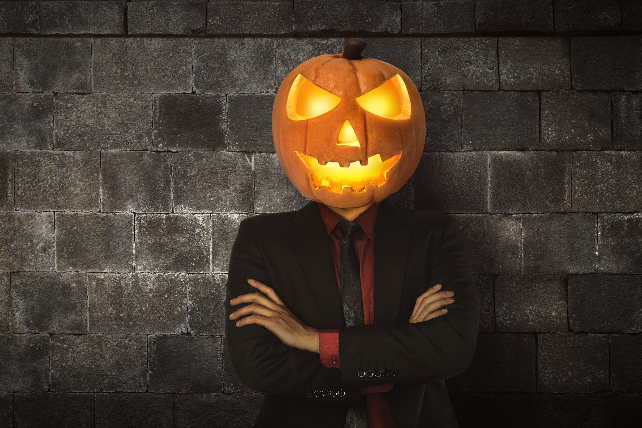 Young halloween man wearing suit with pumpkin head | CustomerThink