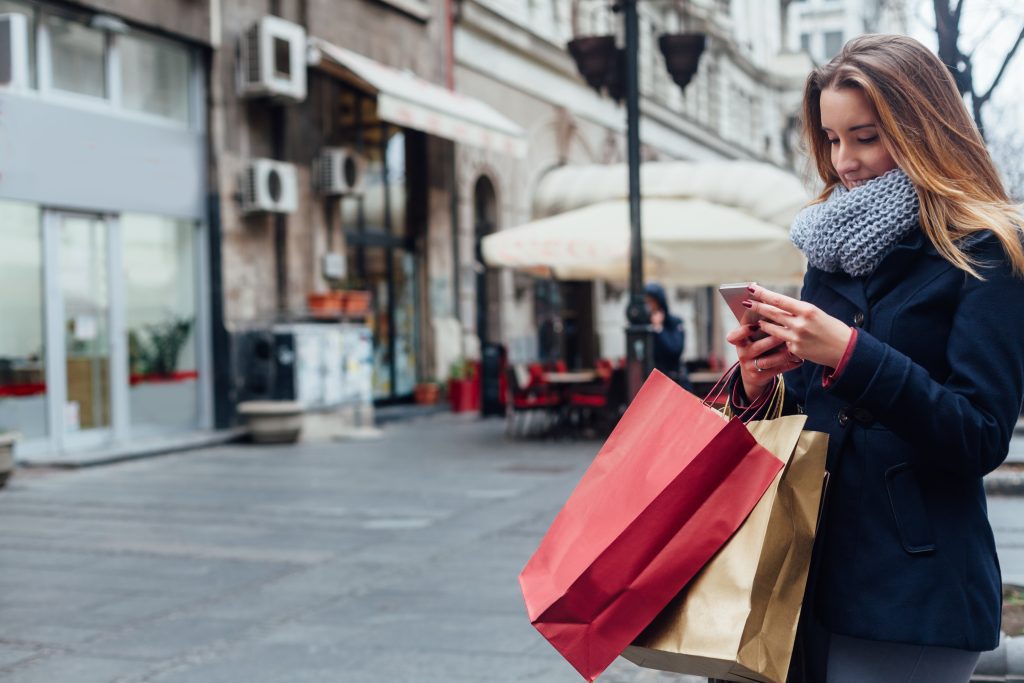 Girl using mobile whilst shopping
